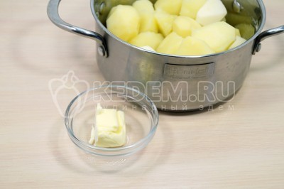 С отварного картофеля слить воду. Добавить 30 грамм сливочного масла.