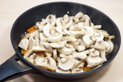 Добавить в сковороду грибы шампиньоны и готовить еще 2-3 минуты.
