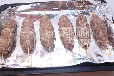 Брать небольшими кусочками и отбивать из руки, в руку, придавая форму. Нанизать на шпажки и выложить на противень с фольгой