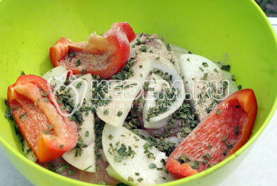 В миске сложить куриные кусочки, крупно нарезанный перец и полукольцами нарезанный лук