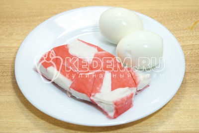 Крабовое мясо разморозить, яйца отварить, остудить и очистить.