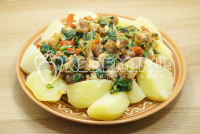 Выложить на блюдо картофель, сверху выложить мясо с зеленью.