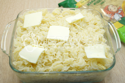 Добавить третью часть макарон и кусочки сливочного масла.
