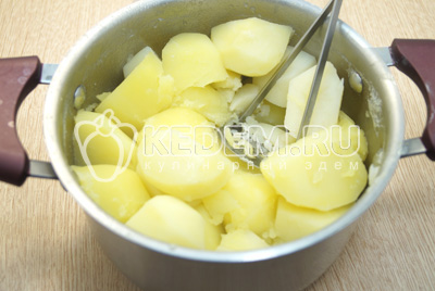 Слить отвар с картофеля, измельчить толкушкой.