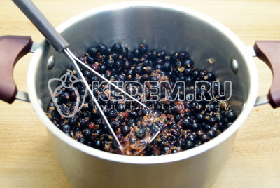 Сложить ягоды в кастрюлю и измельчить толкушкой.