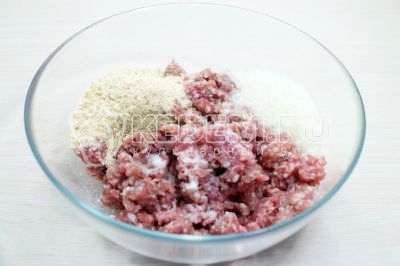 Добавить к фаршу молотый лук, 3 столовые ложки панировочных сухарей, 1/4 чайной ложки соли и 1 щепотку молотого черного перца по вкусу.