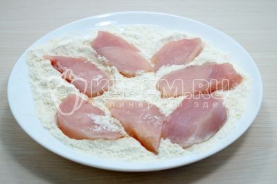 Панировать кусочки курицы в мучной смеси.