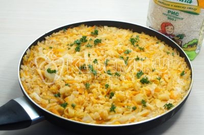Готовую тушеную капусту с рисом посыпать мелко нашинкованной зеленью.