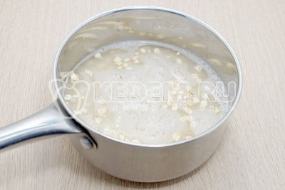 Высыпать хлопья в сотейник и добавить 200 миллилитров воды, поставить варить до закипания.