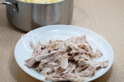 Мясо отделить от костей и кожи. Добавить мясо в кастрюлю.