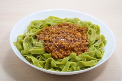 В глубокие тарелки выложить порционно зеленую пасту, мясной густой соус.