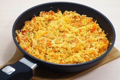 Перемешать пшено с обжаренными овощами.