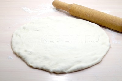 Раскатать тесто вкруг скалкой.