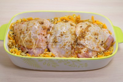 Сверху выложить куриные бедра.