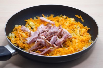 Добавить соломкой нарезанное копченое мясо и обжарить с овощами 2-3 минуты.