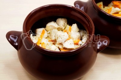 Добавить слой курицы с овощами в горшочки.