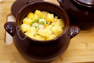 Вынуть горшочки с курицей и картофелем из духовки и немного остудить. Посыпать нашинкованным зеленым луком.