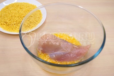 Обмакнуть по очереди каждое куриное филе во взбитое яйцо.