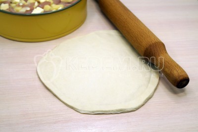 Меньшую часть теста для курника раскатать в круг.