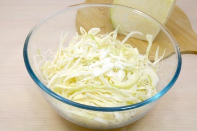 Добавить 1/4 чайной ложки соли и 1/4 чайной ложки сахара. Перетереть капусту руками 2-3 минуты.