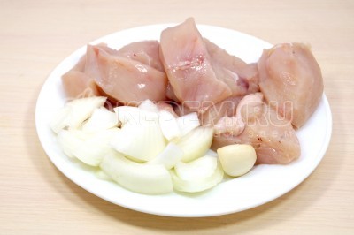 Нарезать куриную грудку и вторую луковицу кусочками. Зубчик чеснока очистить.