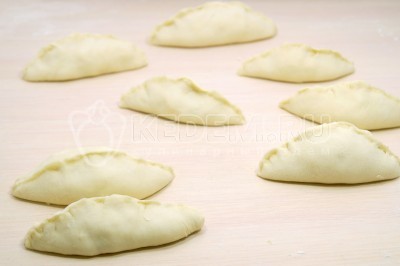 Сформировать пирожки с яйцом и зеленым луком и защипнуть края.
