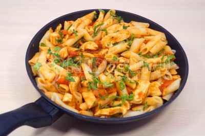 Посыпать макароны с курицей в томатном соусе нарубленной петрушкой.