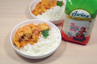 Разложить по тарелкам паприкаш из курицы с гарниром из риса.