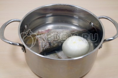 Сложить голову, хвост, плавники и луковицу в кастрюлю.