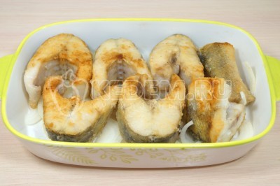 Выложить кусочки обжаренной рыбы.