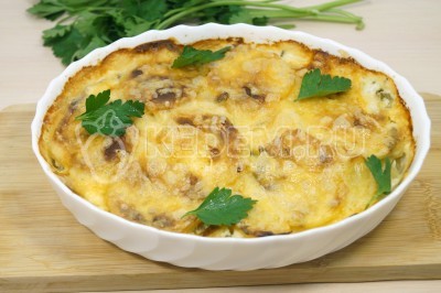 Вынуть картофель с луком и сыром из духовки. Немного остудить и украсить зеленью.