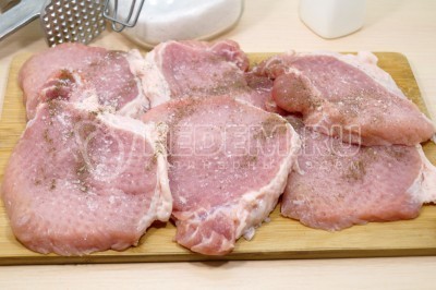 Посолить и поперчить каждый кусочек отбивных.