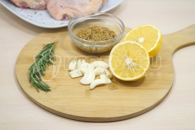 Нарезать кусочками 3-4 зубчика чеснока. Веточку розмарина разобрать на листики. Отрезать половинку лимона и приготовить 2 столовых ложки горчицы с зернами.