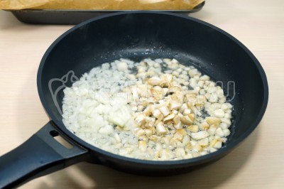 Обжарить ножки грибов с луком, помешивая, 2-3 минуты.