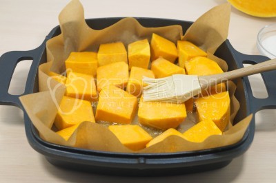 При помощи кисточки смазать каждый кусочек тыквы маслом.