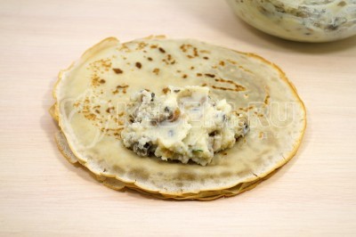 Выложить пару ложек начинки на блинчик.