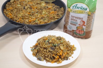 Разложить постный плов с гречкой и грибами по тарелкам.