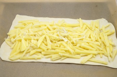 Пергамент с тестом выложить на противень. На слоеное тесто выложить картофель.