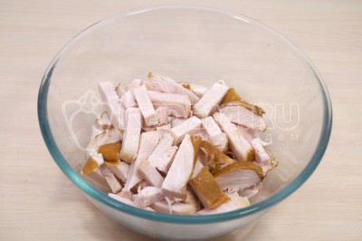 Нарезать курицу небольшими ломтиками в миску.