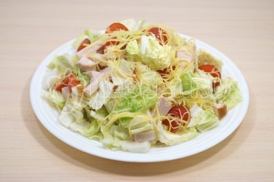 Выложить салат с копченой куриной грудкой и пекинской капустой на плоское блюдо.