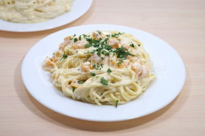 Выложить спагетти с тыквой и сыром на тарелки и украсить мелко нашинкованной зеленью петрушки.