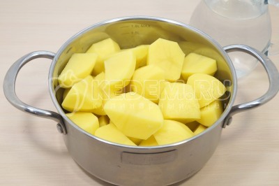 Нарезать картофель на части и сложить в кастрюлю.