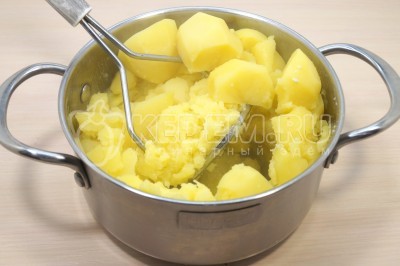 Перетолочь толкушкой картофель в пюре.