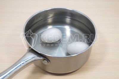 Чтобы приготовить закуску из сыра с чесноком и яйцом нужно 2 яйца отварить, остудить и очистить.