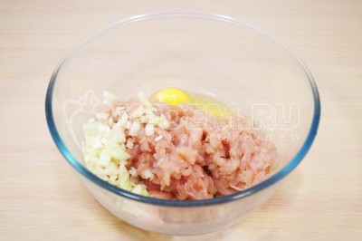 Сложить порубленое куриное филе в миску. Добавить мелко нашинкованную луковицу и 1 яйцо.