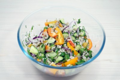 Перемешать салат с перловкой и овощами.