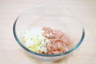 Смешать в миске куриное филе и мелко нашинкованный репчатый лук.