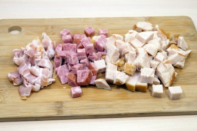 Нарезать кубиками 100 грамм полукопченой колбасы, 200 грамм копченого куриного филе и 50 грамм сырокопченого бекона.