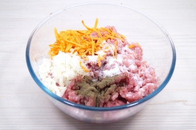 Добавить в мясной фарш мелко нашинкованную луковицу, тертую морковь, 1 щепотку черного молотого перца и 1 чайную ложку соли.