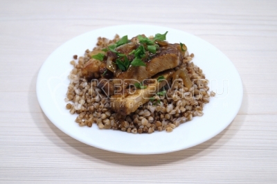 На тарелки выложить по порции гречки с ломтиками мяса. Посыпать мелко нашинкованной петрушкой.
